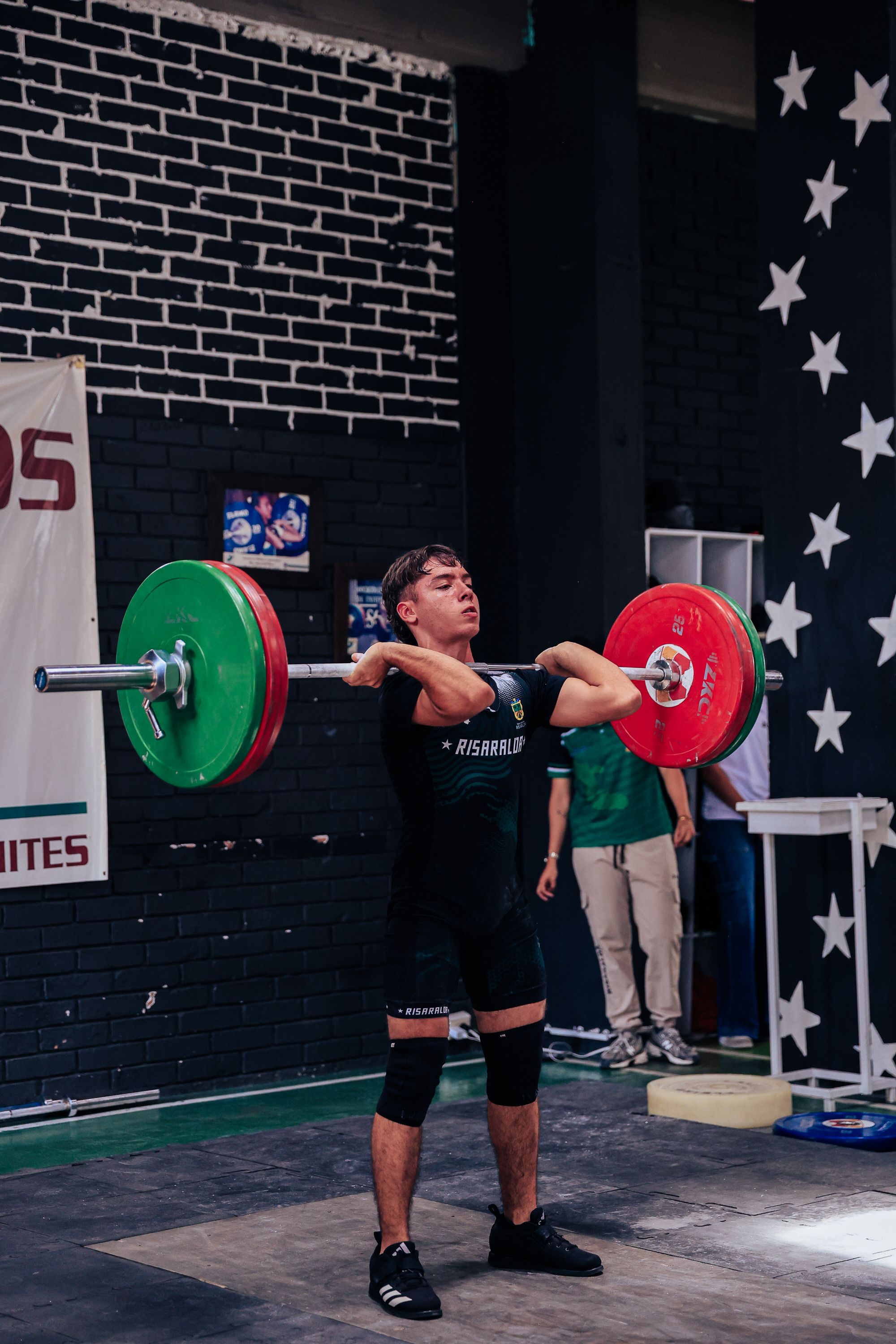 Male athlete performing a clean and jerk lift during a competitive weightlifting event