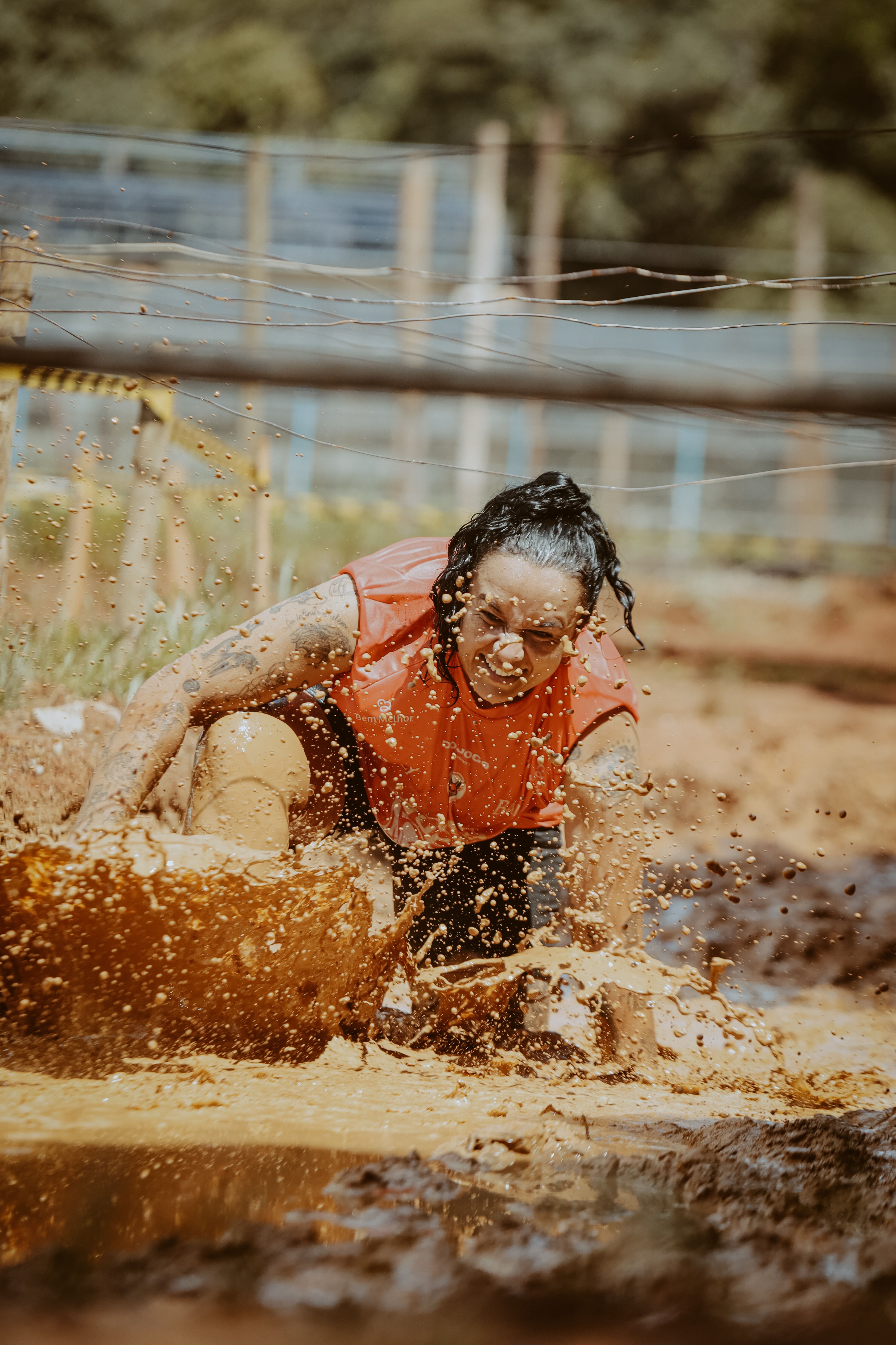 Participant tackling a muddy obstacle during an outdoor obstacle course race